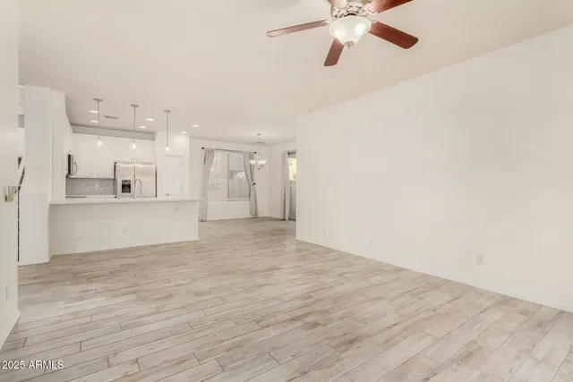an empty room with closet and a chandelier fan