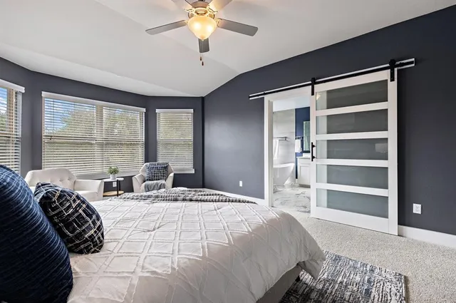 a large bedroom with a large bed and a chandelier