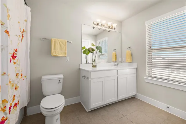 a bathroom with a granite countertop toilet sink and mirror