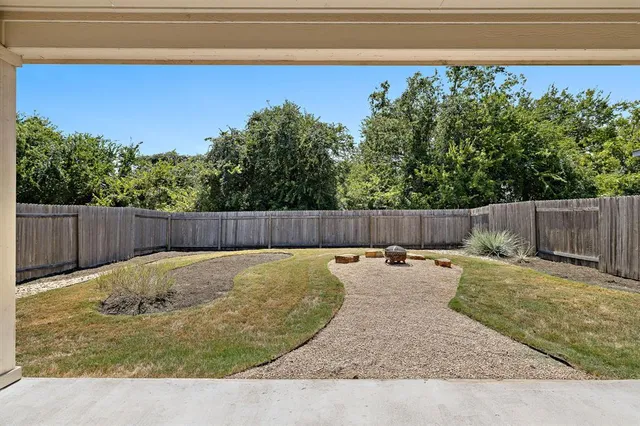 a view of a backyard with wooden fence
