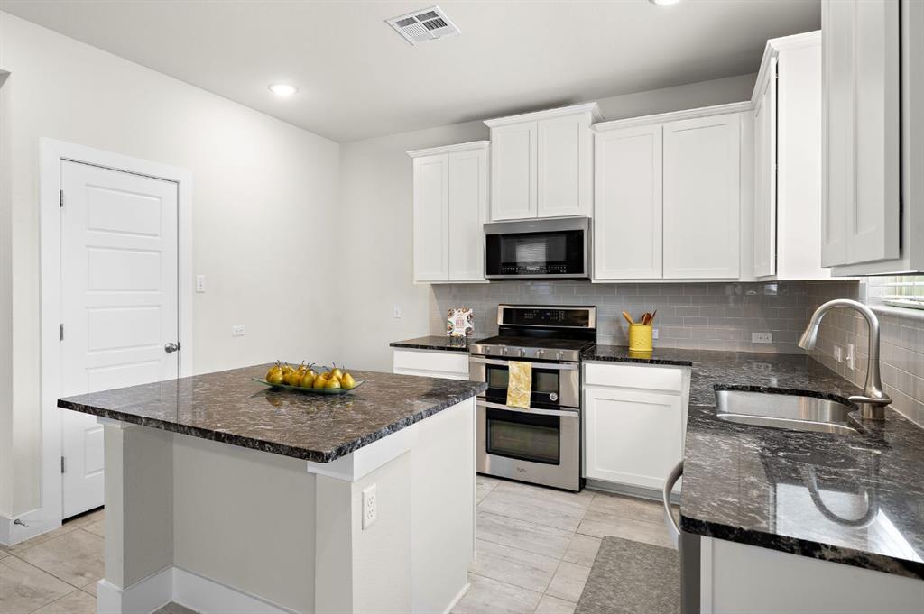 3605 Talladega Trace Austin, TX 78728 - Photo 7 of 27 a kitchen with granite countertop a sink stove and cabinets