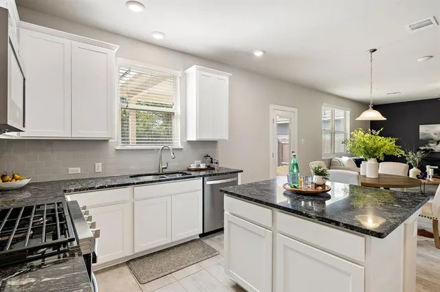 a kitchen with sink stove and cabinets