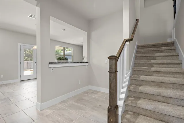 a view of a hallway to rooms and stairs