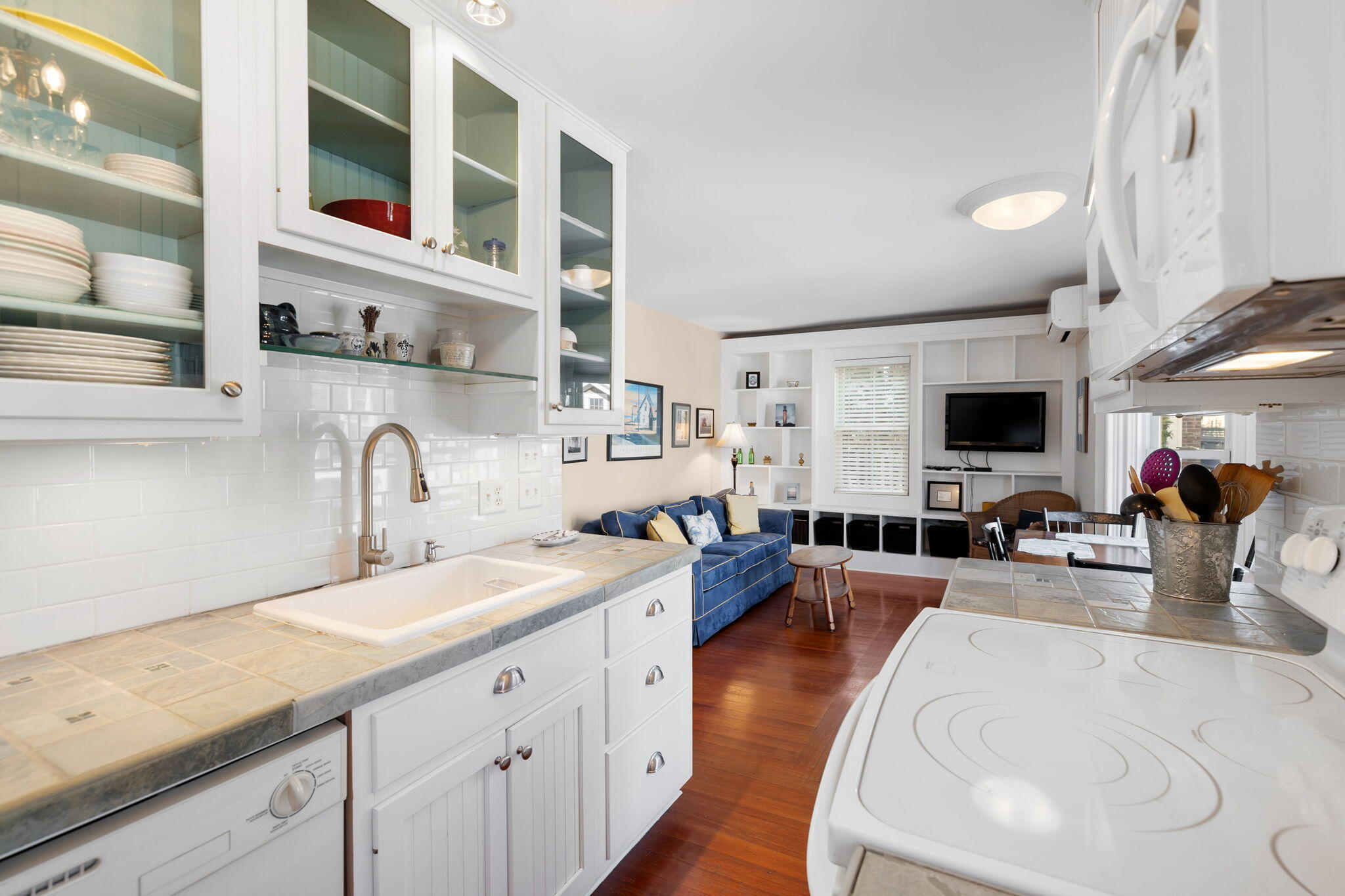 176 Commercial Street, Unit U2 Provincetown, MA 02657 - Photo 15 of 29 a kitchen with stainless steel appliances granite countertop a sink dishwasher stove and white cabinets with wooden floor