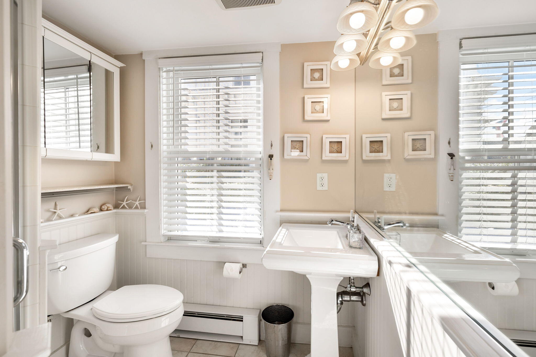 176 Commercial Street, Unit U2 Provincetown, MA 02657 - Photo 22 of 29 a bathroom with a sink a toilet a large mirror and a window