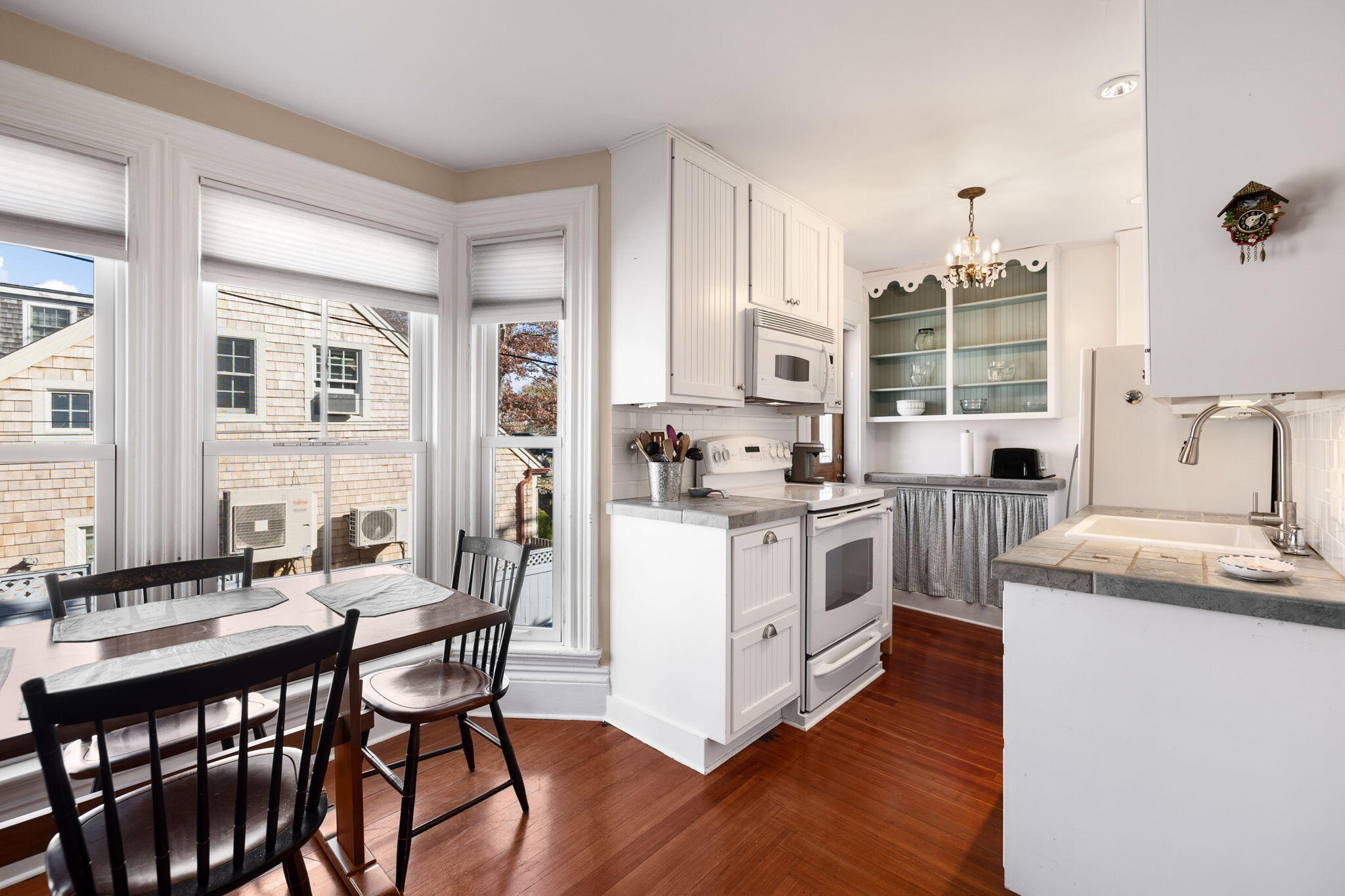 176 Commercial Street, Unit U2 Provincetown, MA 02657 - Photo 10 of 29 a kitchen with a table chairs stove and cabinets