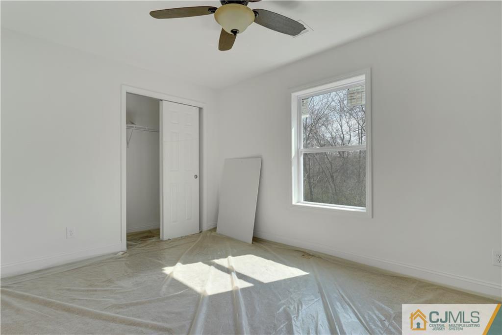 11 Addison Road Howell, NJ 07731 - Photo 19 of 25 an empty room with a ceiling fan and windows