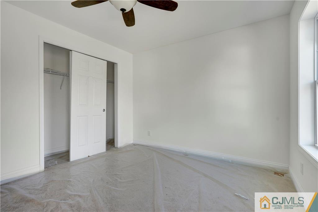 11 Addison Road Howell, NJ 07731 - Photo 22 of 25 an empty room with a ceiling fan and carpet