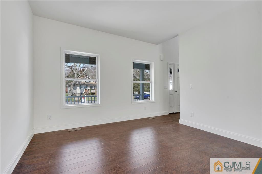 11 Addison Road Howell, NJ 07731 - Photo 4 of 25 an empty room with wooden floor and windows