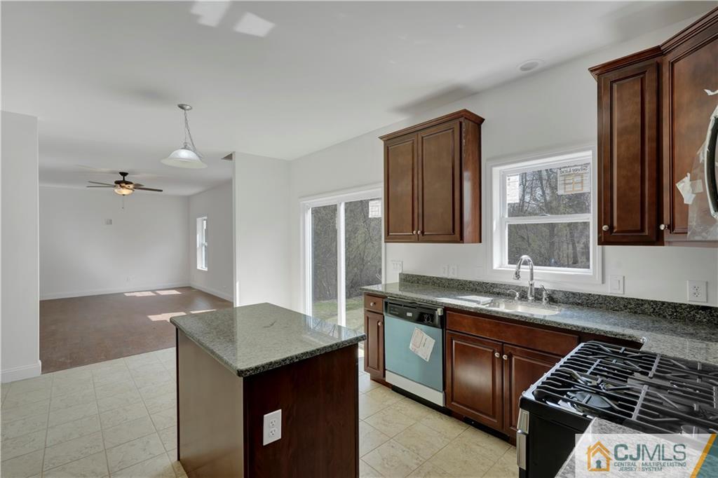 11 Addison Road Howell, NJ 07731 - Photo 8 of 25 a kitchen with granite countertop a sink stove and cabinets
