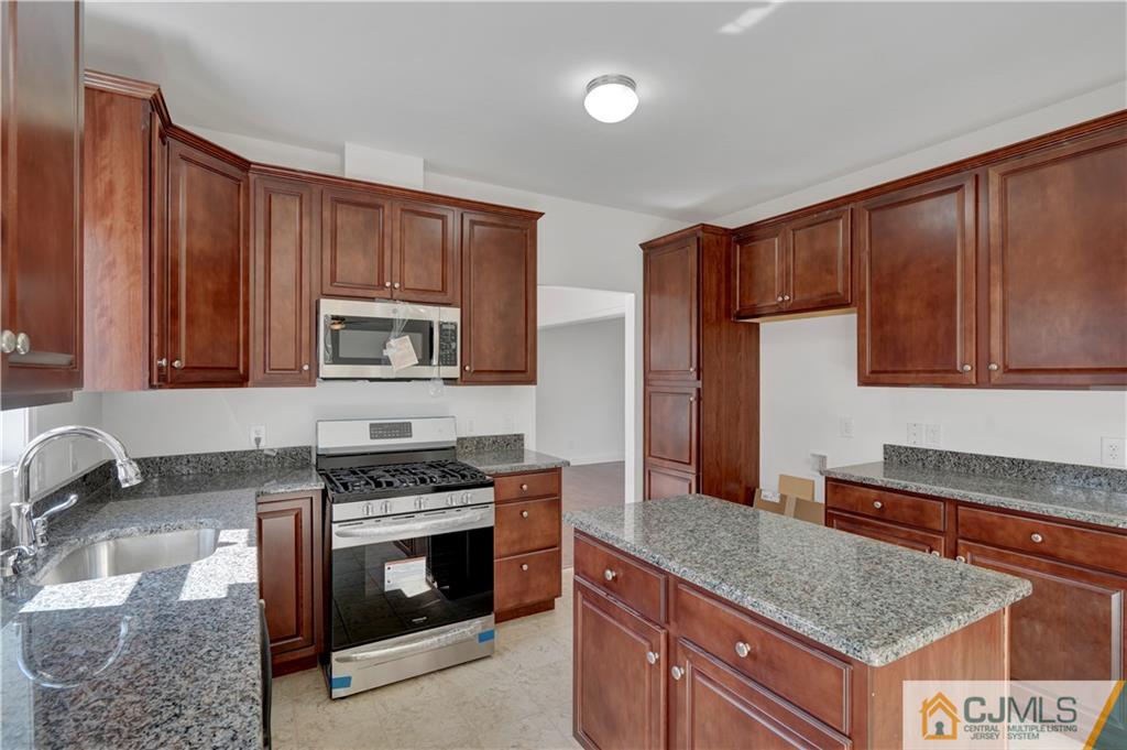 11 Addison Road Howell, NJ 07731 - Photo 10 of 25 a kitchen with granite countertop a stove and a sink