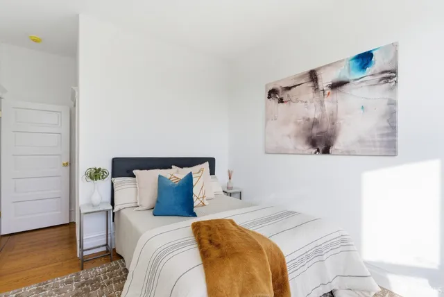 a bedroom with a bed and a painting on the wall