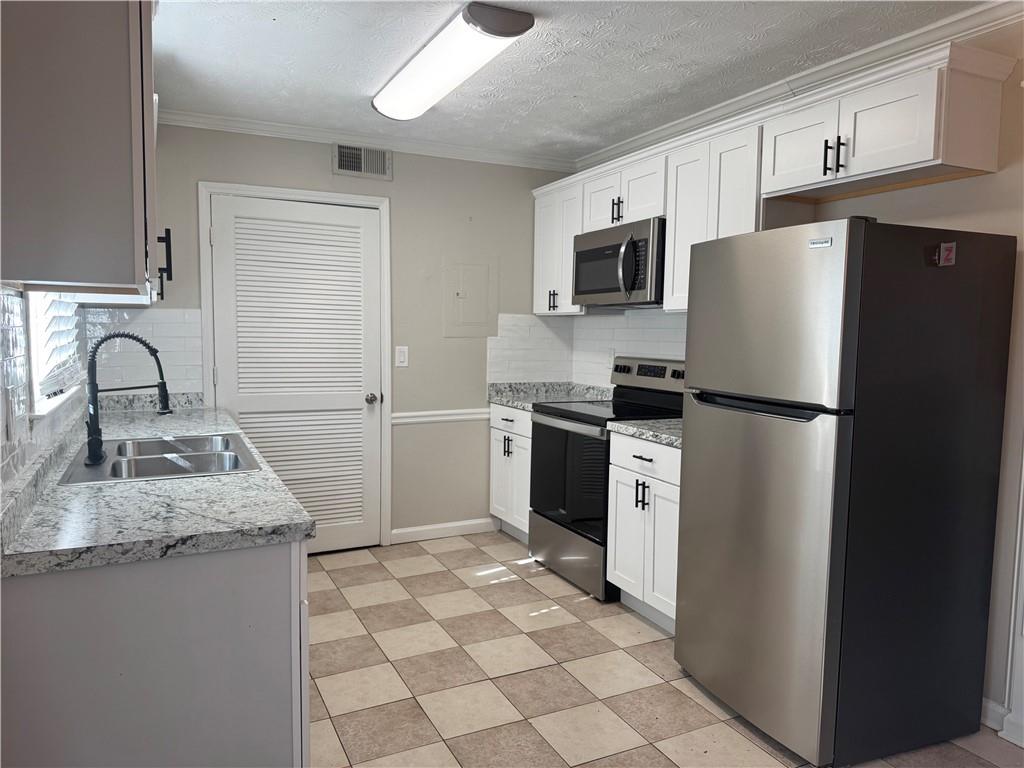 452 Lexington Drive Lawrenceville, GA 30046 - Photo 3 of 9 a kitchen with granite countertop a refrigerator sink stove and microwave