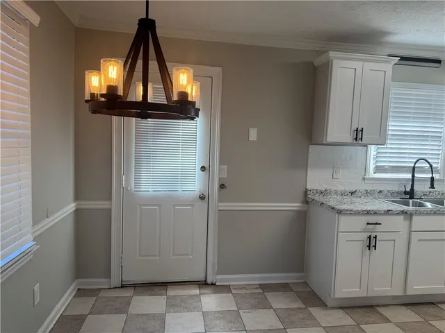 a bathroom with a granite countertop sink and a window