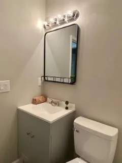 a bathroom with a toilet sink and mirror