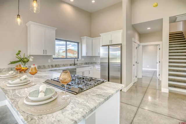 a spacious bathroom with a granite countertop sink toilet a mirror and a shower