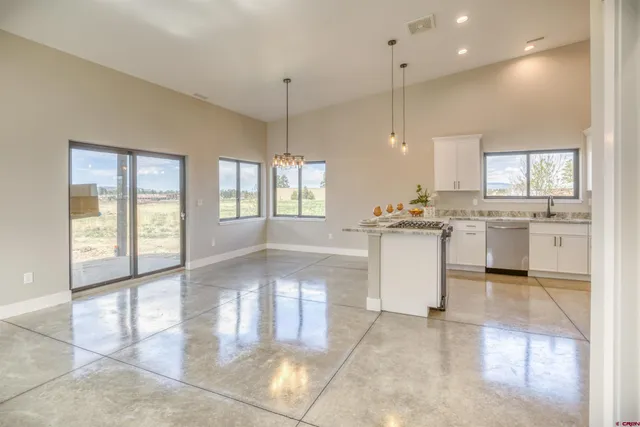 a view of a kitchen with granite countertop lots of counter top space and windows