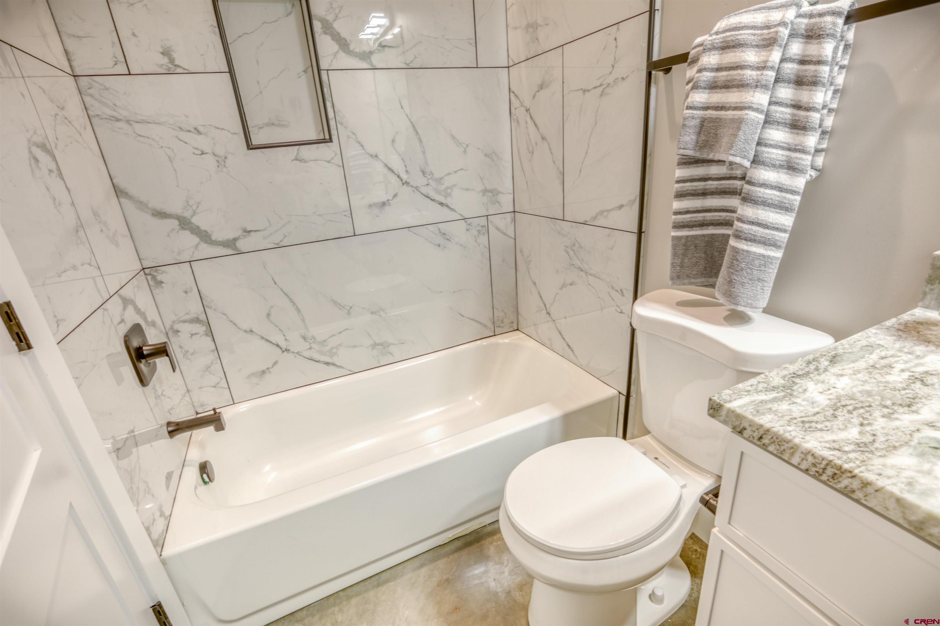 2790 Rock Road, Unit B Pagosa Springs, CO 81147 - Photo 22 of 43 a bathroom with a granite countertop sink toilet and shower