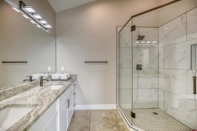 a bathroom with a granite countertop double vanity sink and a mirror