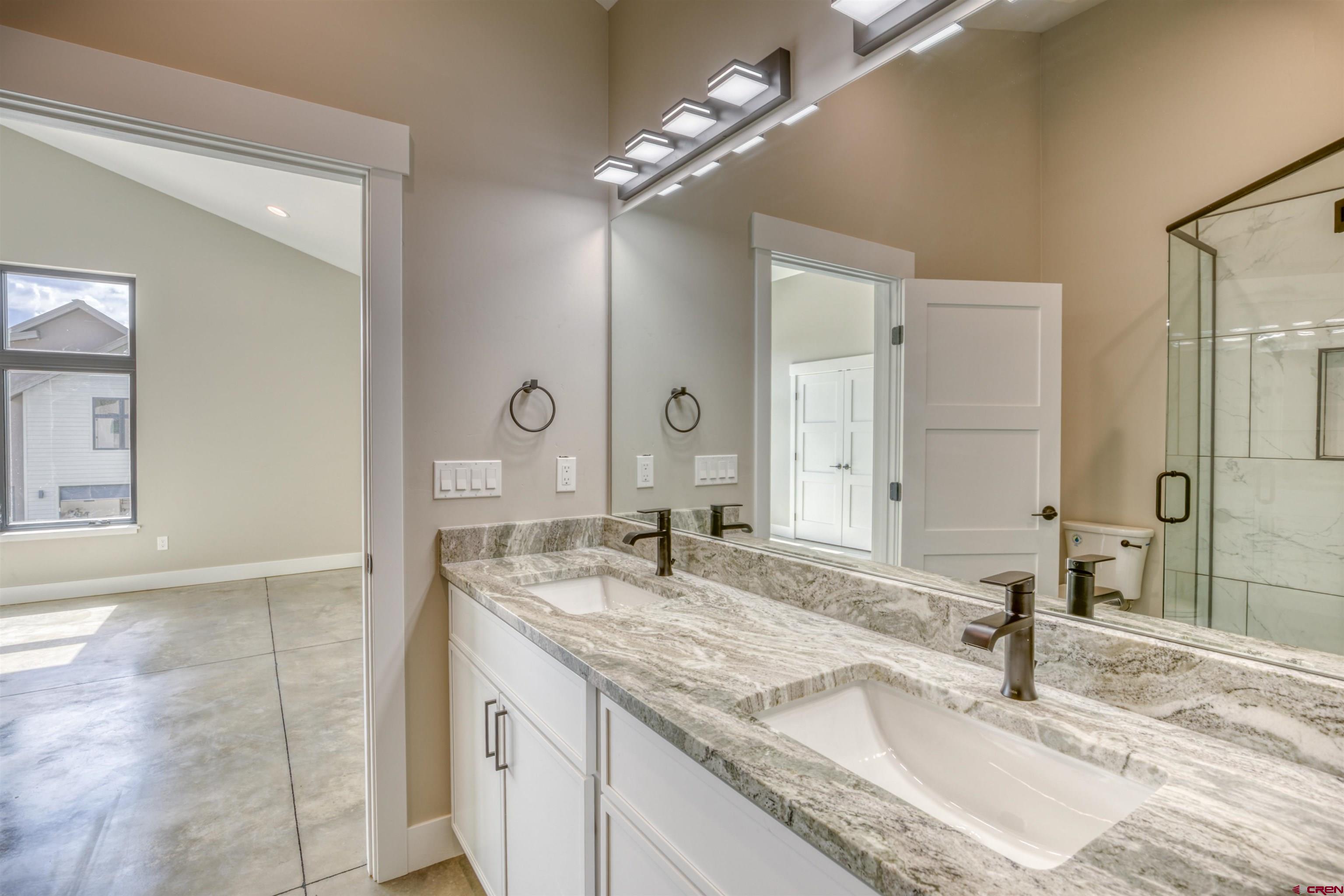 2790 Rock Road, Unit B Pagosa Springs, CO 81147 - Photo 27 of 43 a bathroom with a granite countertop double vanity sink and a mirror