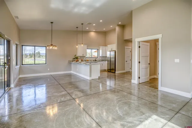 a view of a kitchen with refrigerator and wooden floor