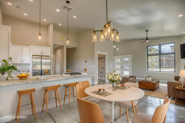 a living room with furniture kitchen and a table