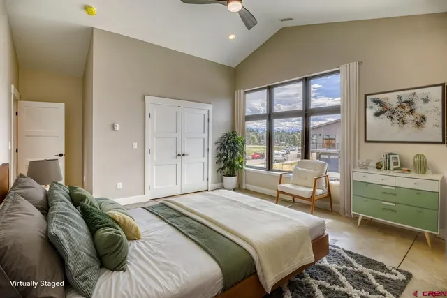 a spacious bedroom with a bed and a large window