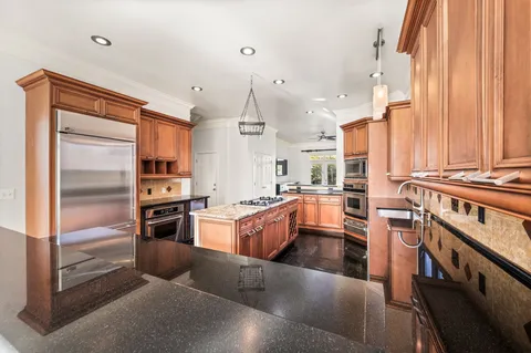a kitchen with stainless steel appliances granite countertop a refrigerator a sink and a stove