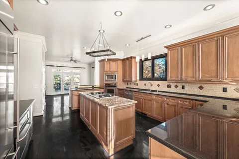 a kitchen with stainless steel appliances a sink stove and cabinets
