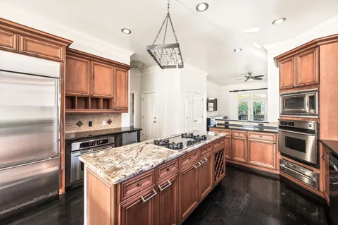 a kitchen with stainless steel appliances granite countertop a stove a sink and a refrigerator
