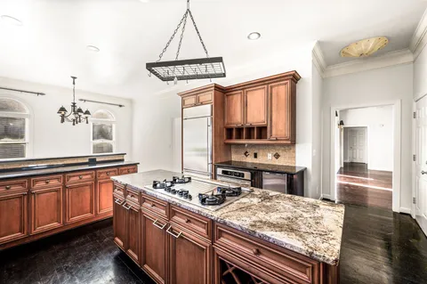 a kitchen with stainless steel appliances granite countertop a stove a sink dishwasher and cabinets with wooden floor