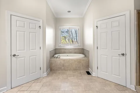 a bathroom with a granite countertop sink a large mirror and a bathtub