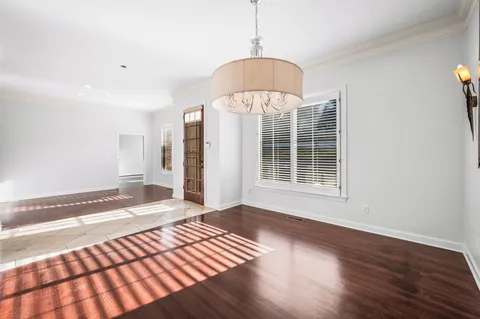 a view of an empty room with wooden floor windows