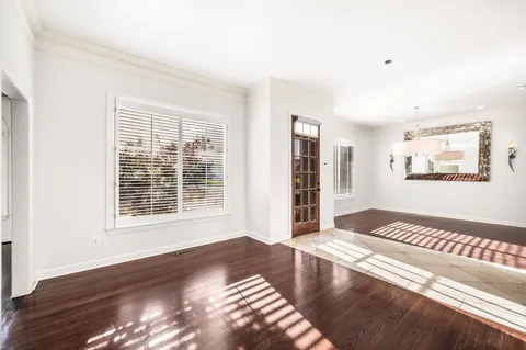 a view of a bedroom with wooden floor and window