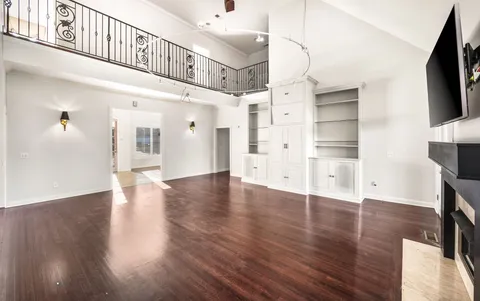a view of a livingroom with wooden floor and a flat screen tv