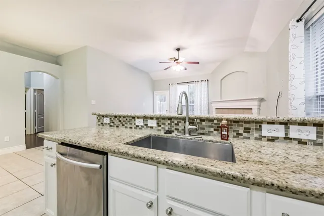 a kitchen with stainless steel appliances granite countertop a sink and a refrigerator