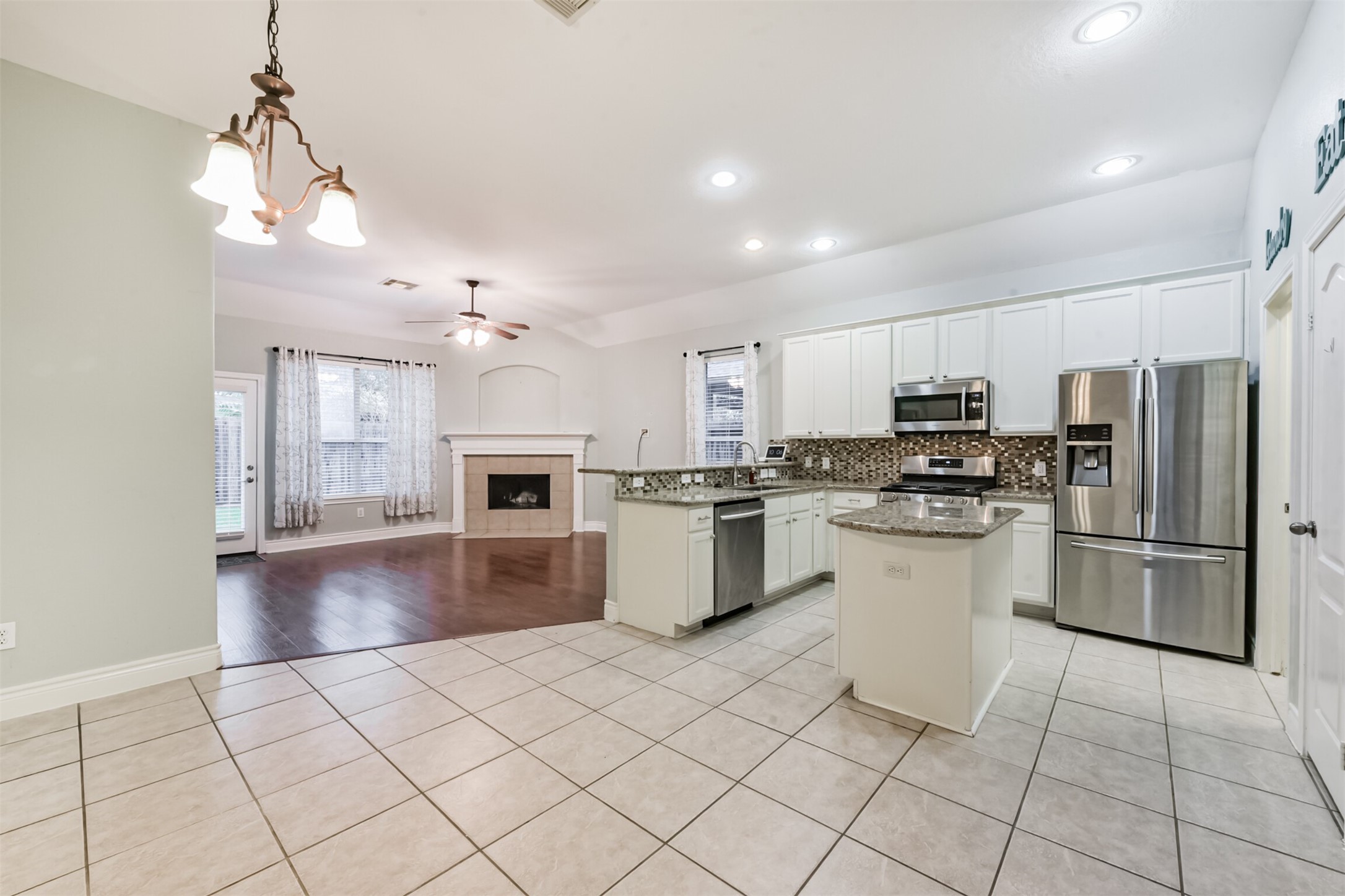 1065 Brigid Court Dickinson, TX 77539 - Photo 15 of 37 a kitchen with a refrigerator a stove top oven a sink dishwasher and a refrigerator with wooden floor