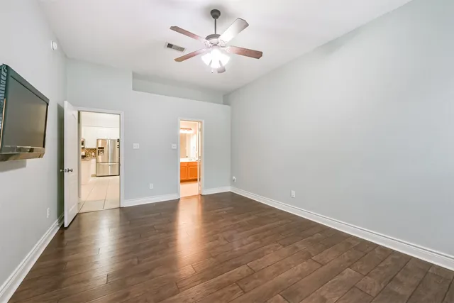 a view of an empty room with window and wooden floor