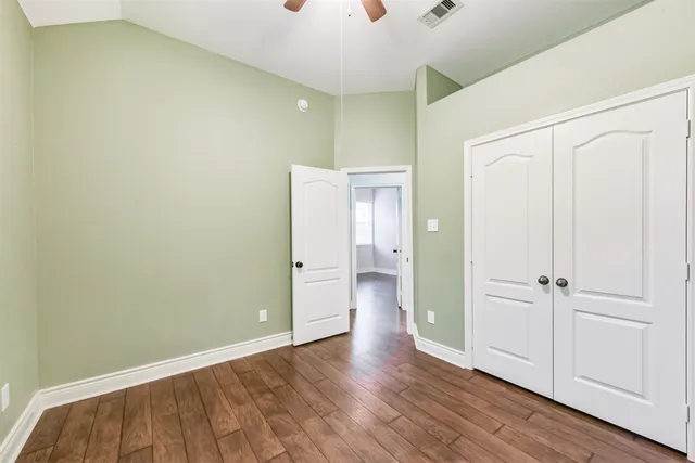 an empty room with wooden floor and closet