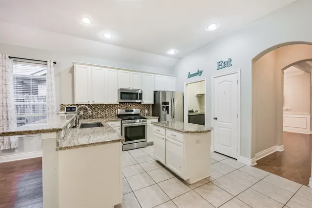 a kitchen with a sink a counter top space and appliances
