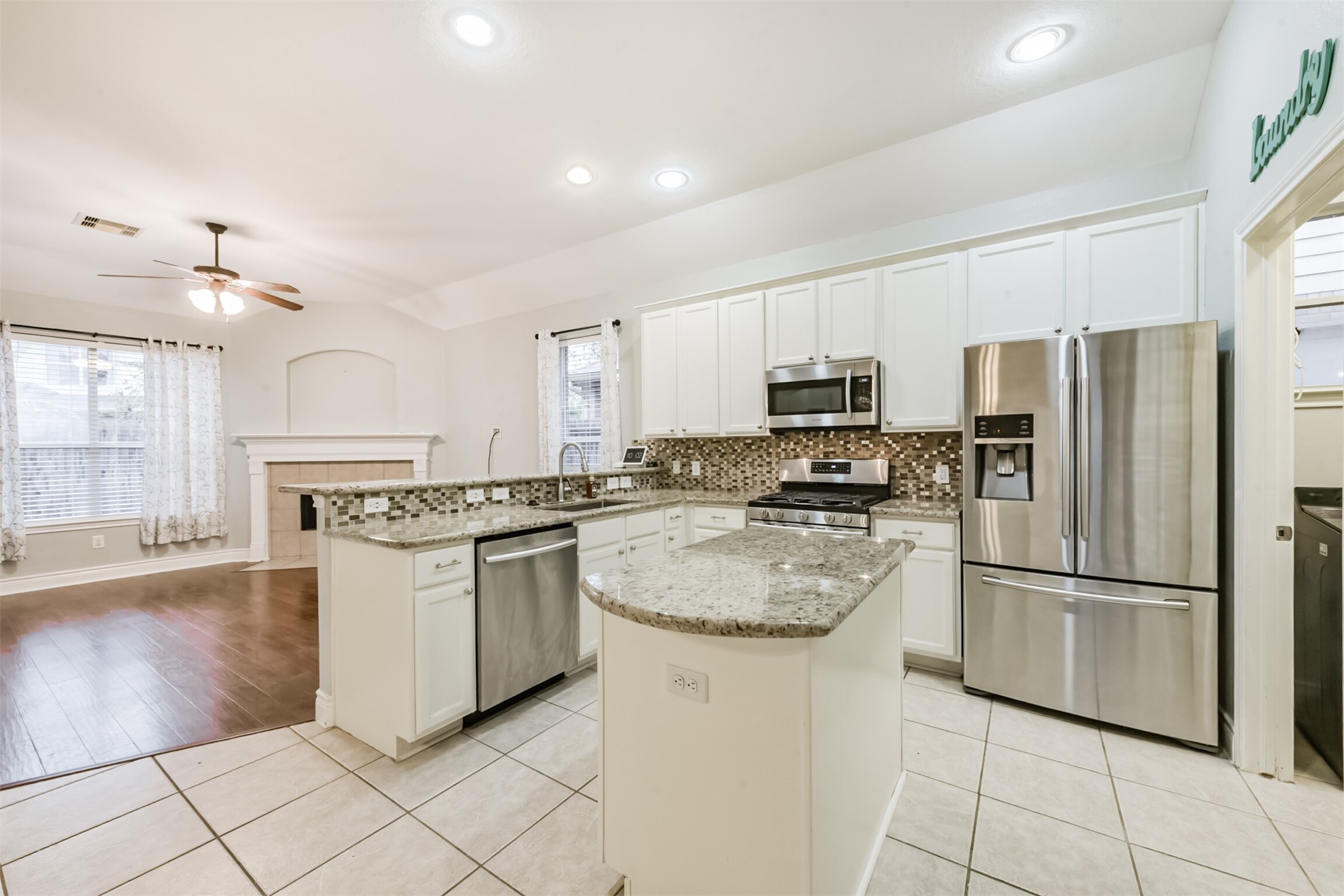 1065 Brigid Court Dickinson, TX 77539 - Photo 10 of 37 a kitchen with stainless steel appliances granite countertop a refrigerator a stove a sink and a microwave