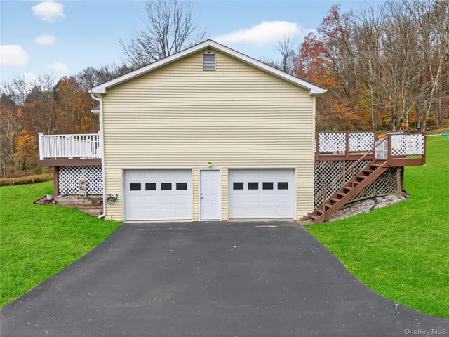a view of a house with a yard and a garage