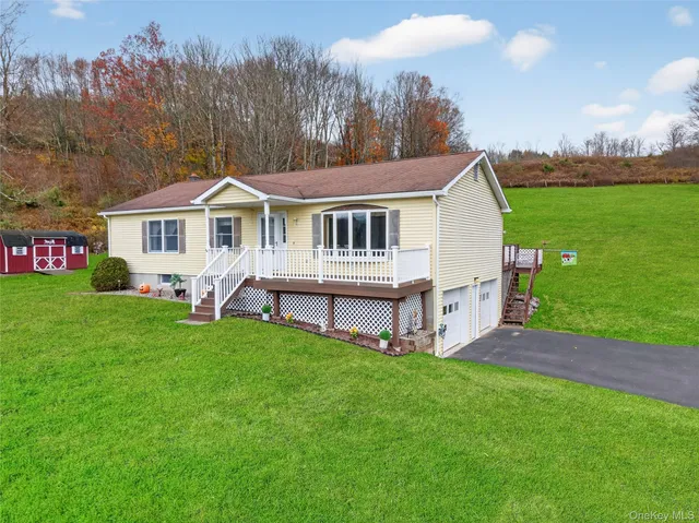 a view of a house with a yard and sitting area