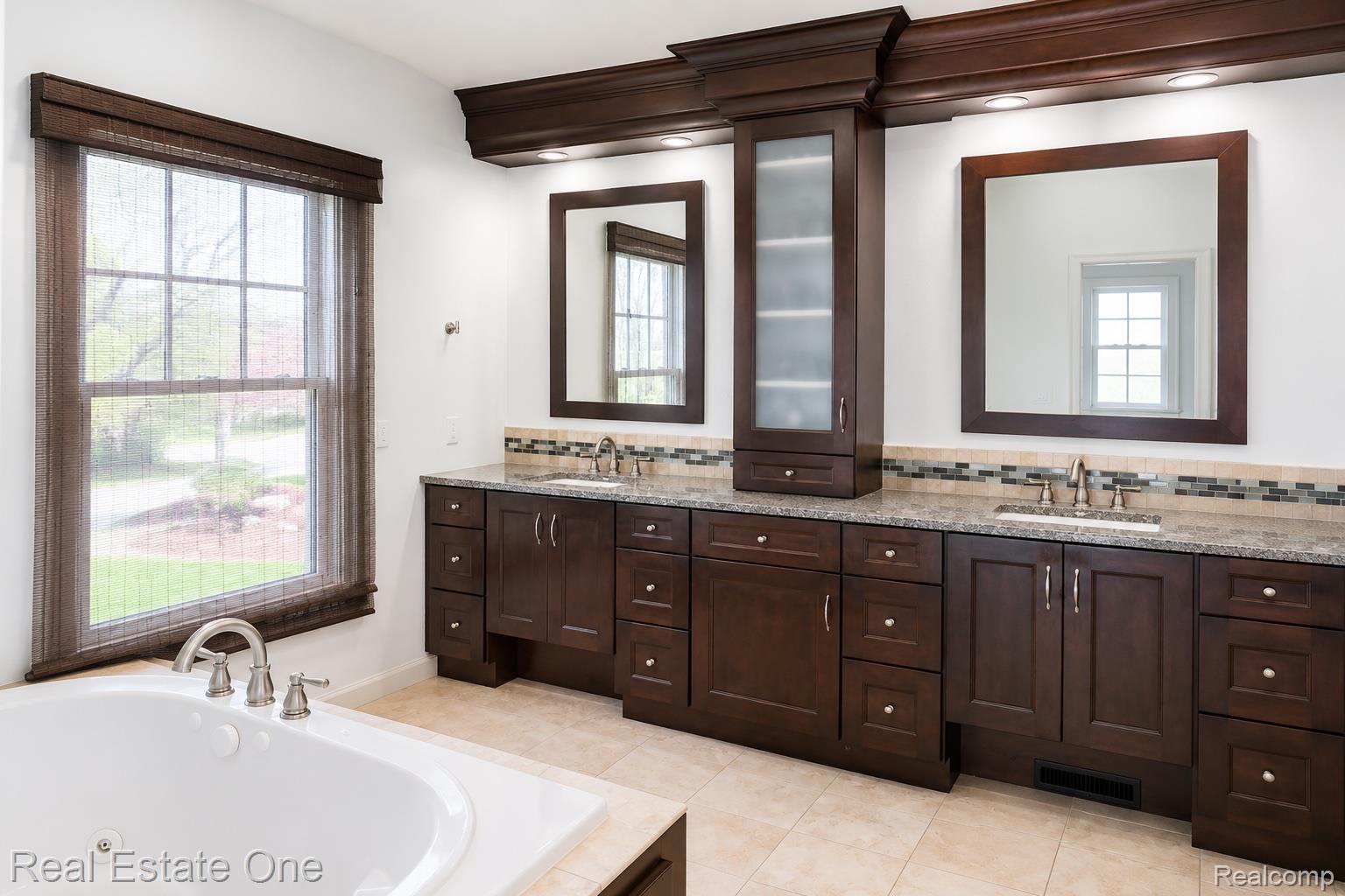 1141 Sandy Ridge Drive Rochester, MI 48306 - Photo 7 of 9 Dual sink vanity with dark wood-finish cabinetry, granite-style countertops, and mosaic tile backsplash