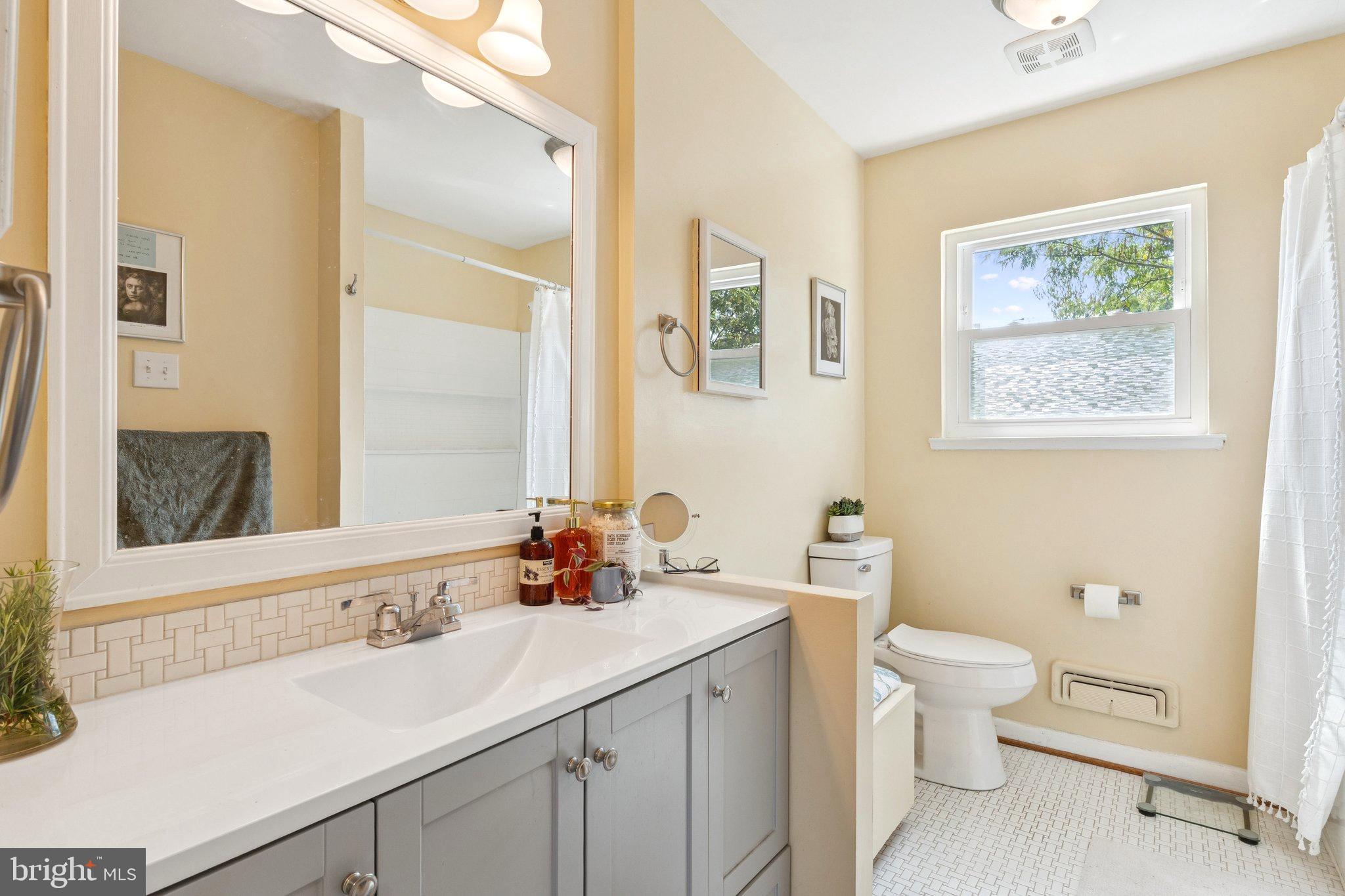 6200 Gilston Park Road Catonsville, MD 21228 - Photo 12 of 34 a bathroom with a double vanity sink toilet and a mirror