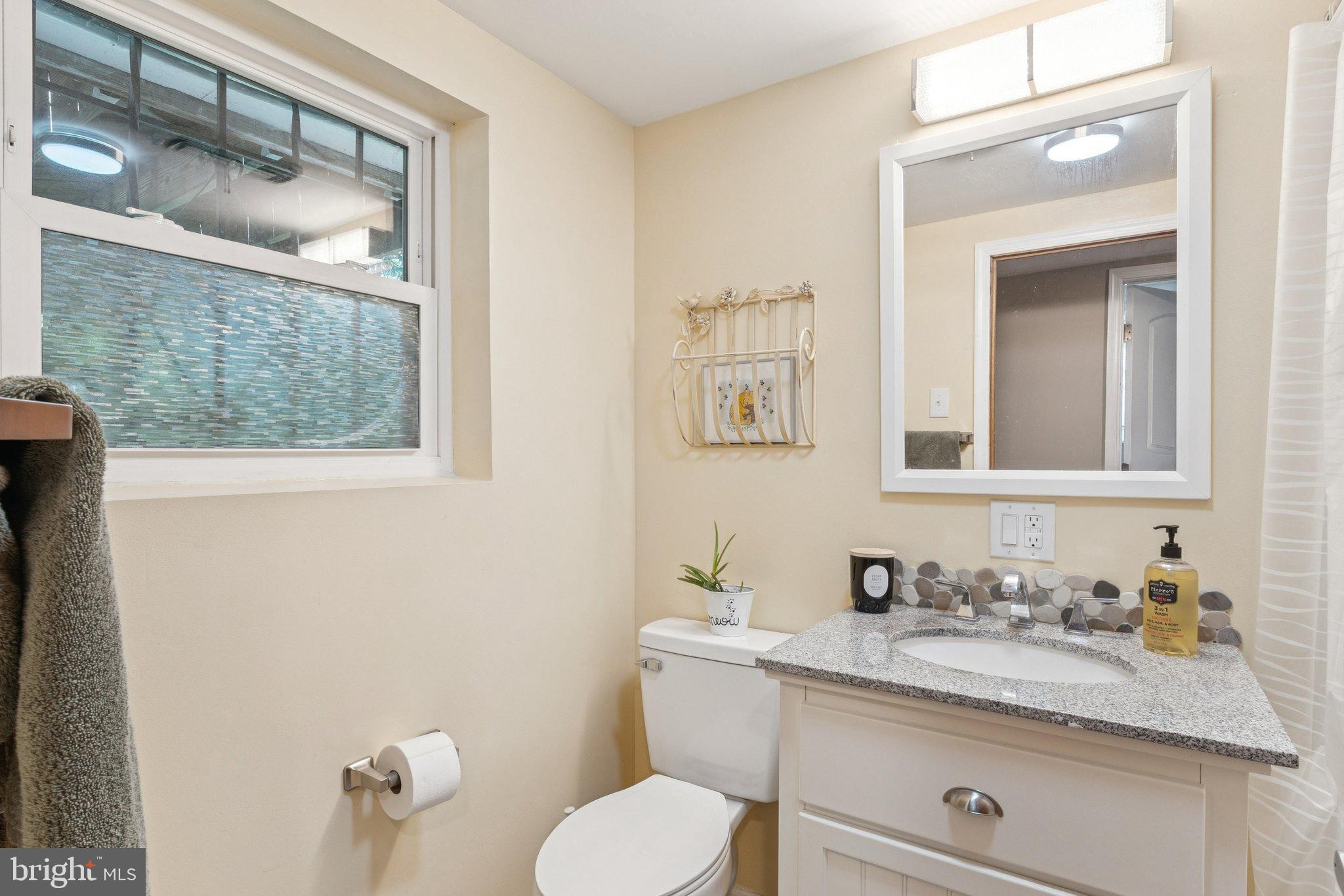 6200 Gilston Park Road Catonsville, MD 21228 - Photo 22 of 34 a bathroom with a granite countertop toilet a sink and mirror