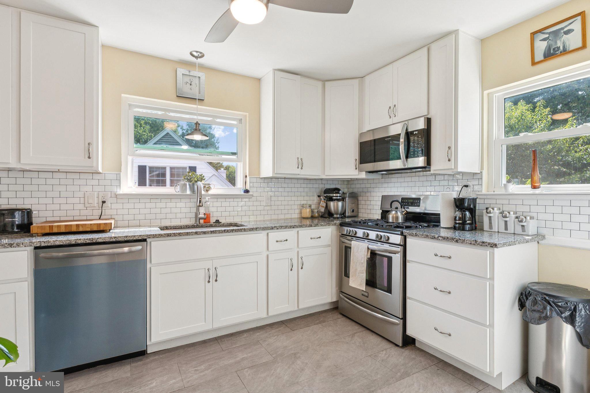6200 Gilston Park Road Catonsville, MD 21228 - Photo 10 of 34 a kitchen with white cabinets appliances a sink and a window