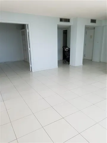 an empty room with walk in closet and wooden floor