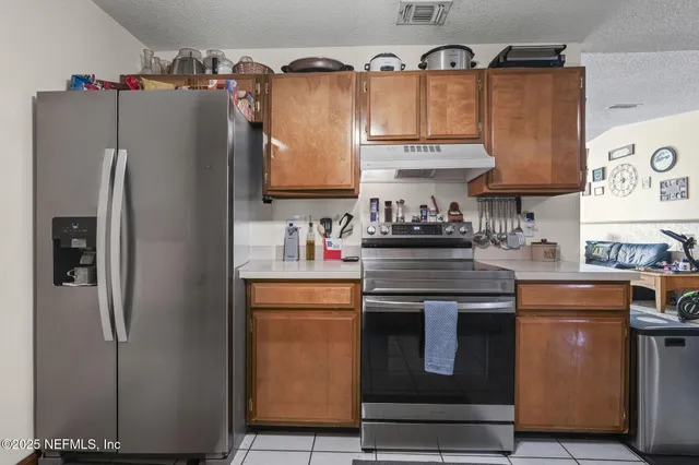 a kitchen with stainless steel appliances granite countertop a refrigerator and a stove