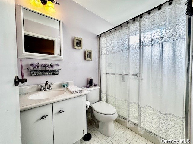 145 Edinburgh Drive, Unit 145 Ridge, NY 11961 - Photo 15 of 18 a bathroom with a granite countertop sink toilet a mirror and shower